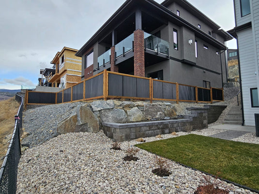 Modern home with black corrugated metal fence from BarrierBoss