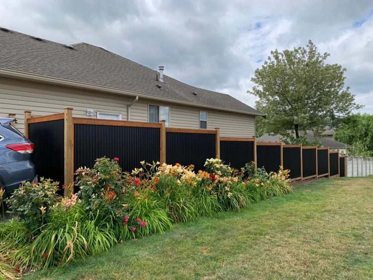 black corrugated metal fence with wood posts